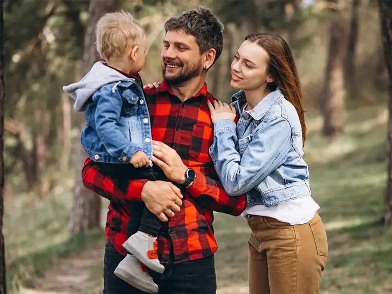 Family smiling taking a walk on the woods.