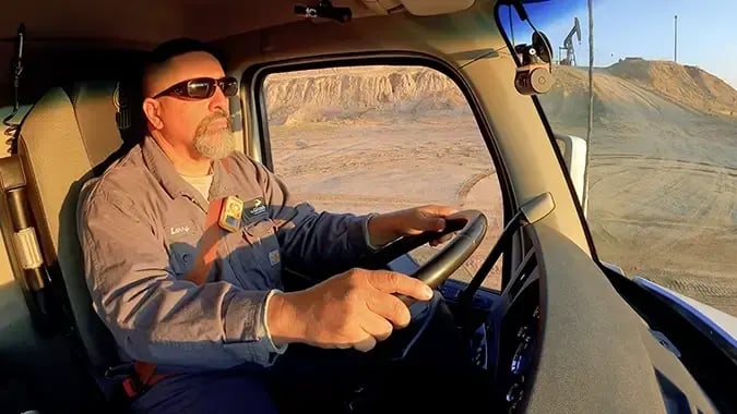 Gazelle truck driver on a sandy worksite.